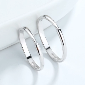 Minimalist pair of S925 sterling silver hoop earrings with polished finish on white surface