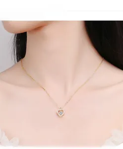 Close-up of a heart necklace with a sparkling center stone on a model for jewelry detail