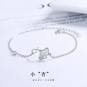 Detail of s925 silver bracelet featuring a ginkgo leaf charm and sparkling zircon gem