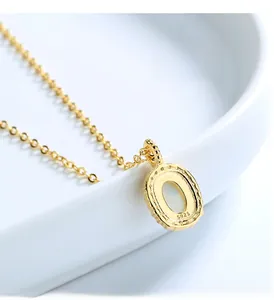 Macro shot of S925 sterling silver gold pendant necklace with polished finish and logo
