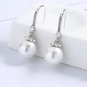 Dettaglio macro di orecchini in argento S925 con perle barocche e pietre su base bianca