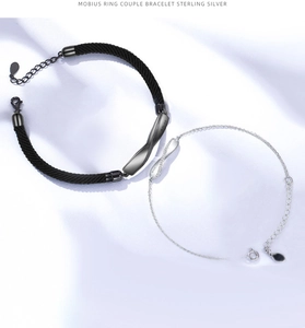 Dettaglio di bracciali Möbius per coppia con corda intrecciata nera e catena in argento 925