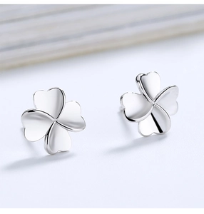 Macro shot of polished S925 sterling silver four-leaf clover stud earrings for women