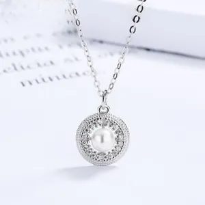 Detailed macro view of S925 silver hollow round pendant with white pearl and diamonds