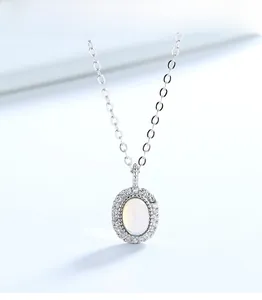 Detail of silver moonstone pendant featuring cat-eye stone and halo crystals on a fine chain