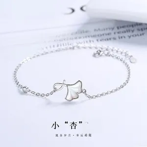 Macro detail of S925 silver ginkgo leaf bracelet with white shell and zircon