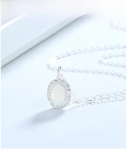 Macro detail of oval moonstone pendant necklace in S925 sterling silver with halo diamonds