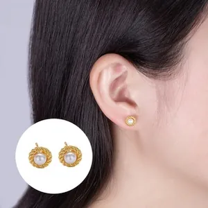 Close-up of model wearing a freshwater pearl earring with twisted gold metal border