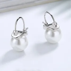 Detail shot of elegant white freshwater pearl ear clips with polished S925 silver hooks