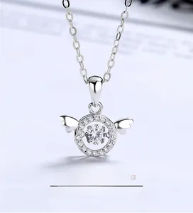 Vue macro du pendentif ailes d'ange en argent avec une pierre en forme de cœur brillant