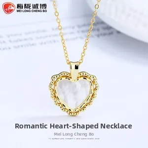 Macro view of sterling silver heart necklace with gold beaded edge and mother of pearl