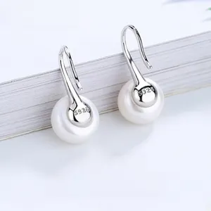Macro shot of S925 sterling silver ginkgo leaf hook earrings with glossy white pearls