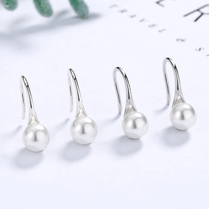 Close-up of elegant S925 sterling silver long hook earrings with glossy white pearls