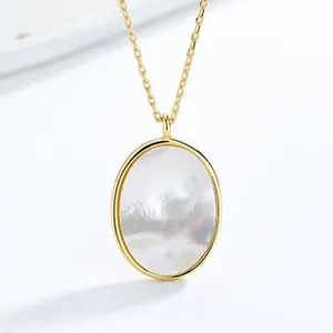 Close-up of elegant gold oval necklace featuring a shimmering white mother of pearl inlay
