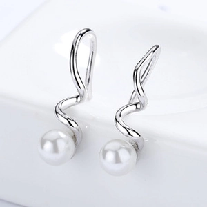 Close-up of spiral S925 sterling silver earrings with elegant white round pearls
