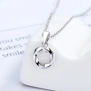 Detailed view of 925 sterling silver Mobius loop necklace hanging on ceramic decor