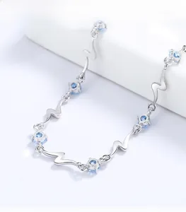 Close-up of silver wavy link bracelet with sparkling blue zircon stone decorations