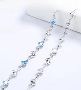 Detailed close-up of a silver bracelet with wavy links, blue crystals and white zircons
