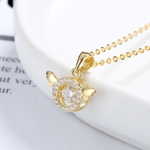 Collier ailes d'ange doré avec pendentif coeur scintillant sur assiette en céramique