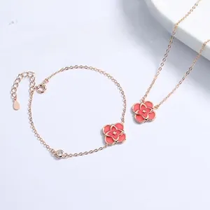 Detail of rose gold clover necklace and bracelet set with pink petals and crystals