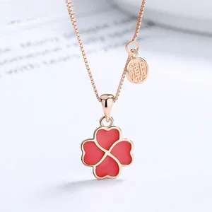 Macro view of 925 silver red clover pendant necklace with rose gold finish and logo tag