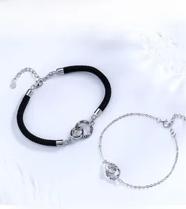 Detail of S925 sterling silver interlocking rings on braided cord with heart engraving