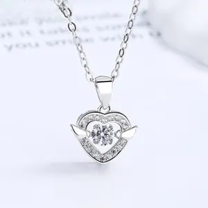 Detail view of heart necklace with wings featuring a sparkling dancing stone center