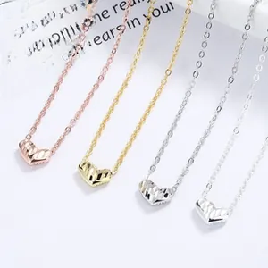 Detail view of heart-shaped faceted pendants in rose gold, gold and silver finishes