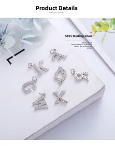 Macro detail of S925 sterling silver letter pendants with CZ diamonds on book pages