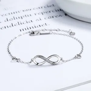 Macro shot of S925 silver infinity bracelet featuring micro-pave crystals and heart charm