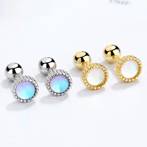 Macro detail of brushed thread stud earrings with opal stone and beaded disc frame
