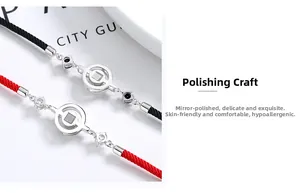 Detail of polished 925 sterling silver charms on red and black woven couple bracelets