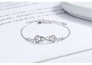 Macro detail of 925 sterling silver infinity heart bracelet with white zircon stones