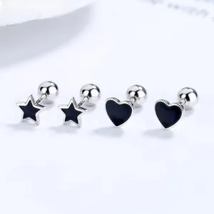 Macro detail of 925 silver star and heart studs with black enamel and screw back balls