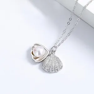 Gros plan détaillé d'un collier tulipe en argent 925 avec une perle dans un pendentif coquillage