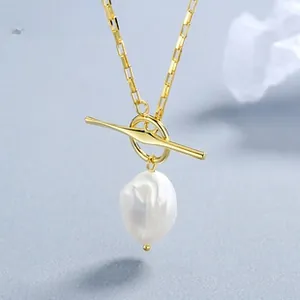 Détail d'un collier doré en argent 925 avec fermoir à bascule et perle baroque