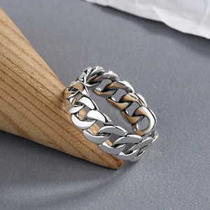 Gros plan d'une bague chaîne cubaine vintage en argent S925 sur support en bois