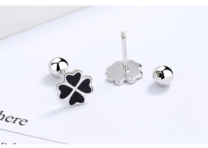 Macro shot of S925 sterling silver four-leaf clover earrings with black enamel and screw back