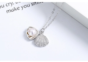 Detail of S925 silver shell necklace with white pearl and sparkling zircon stone