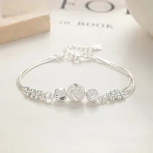 Macro view of multi-layer S925 silver bell bracelet with hollow beads and clover charm