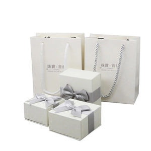 Set of cream jewelry gift boxes and bags featuring elegant grey satin ribbon bows