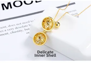 Close-up of golden hollow bell pendant featuring intricate craftsmanship and openable design