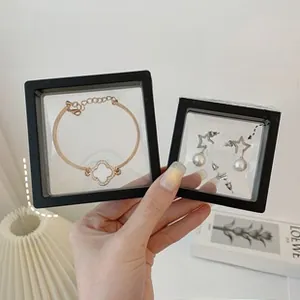 Handheld jewelry box with PE film protecting a clover bracelet and star earrings