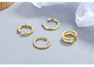 Detailed macro view of S925 sterling silver golden ear cuffs with twisted and chain designs