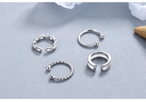 Macro detail of four S925 sterling silver ear cuffs with twisted and beaded textures