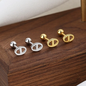 Detailed close-up of oval pig nose stud earrings in gold and silver finishes
