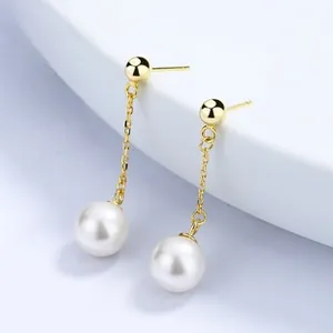 Detailed close-up of 925 silver gold leaf earrings with long hanging white pearls