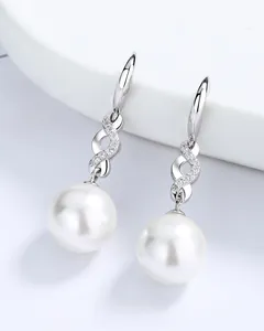 Detailed close-up of a white round pearl earring with a zircon-encrusted figure-eight silver link