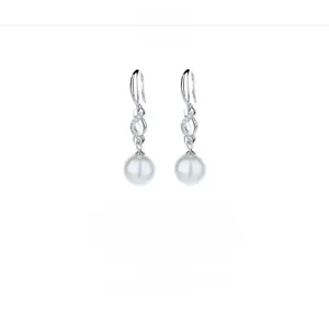 Detail of silver S925 drop earrings with white round pearl and zircon infinity design