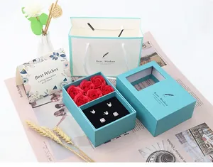 Tiffany blue jewelry gift box with red roses and elegant silver accessories layout
